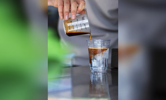 Espresso wordt over tonic en ijs geschonken door barista