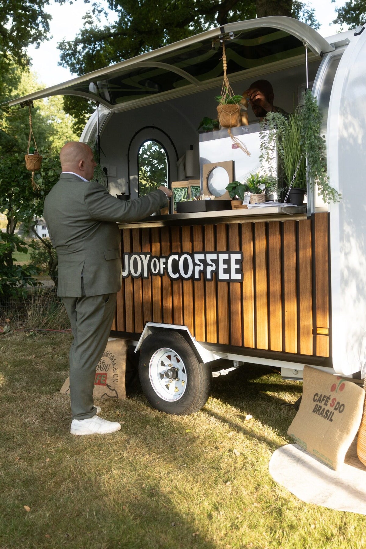 Barista serveert een gast vanuit de koffietrailer op een bruiloft