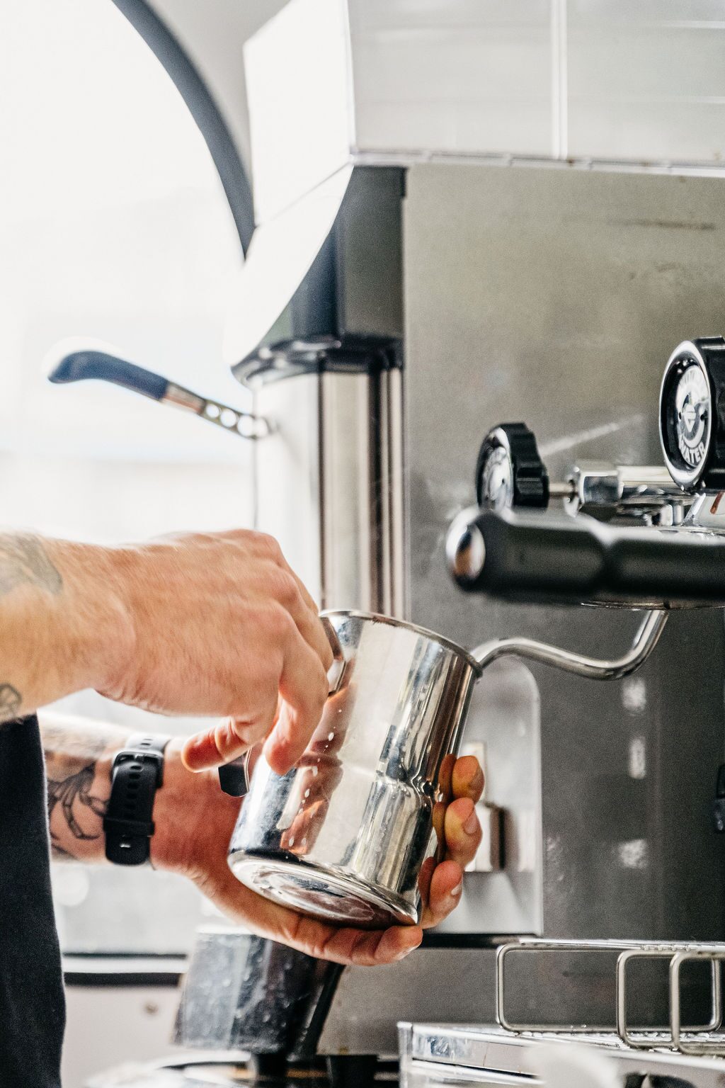 Barista schuimt melk op voor een cappuccino