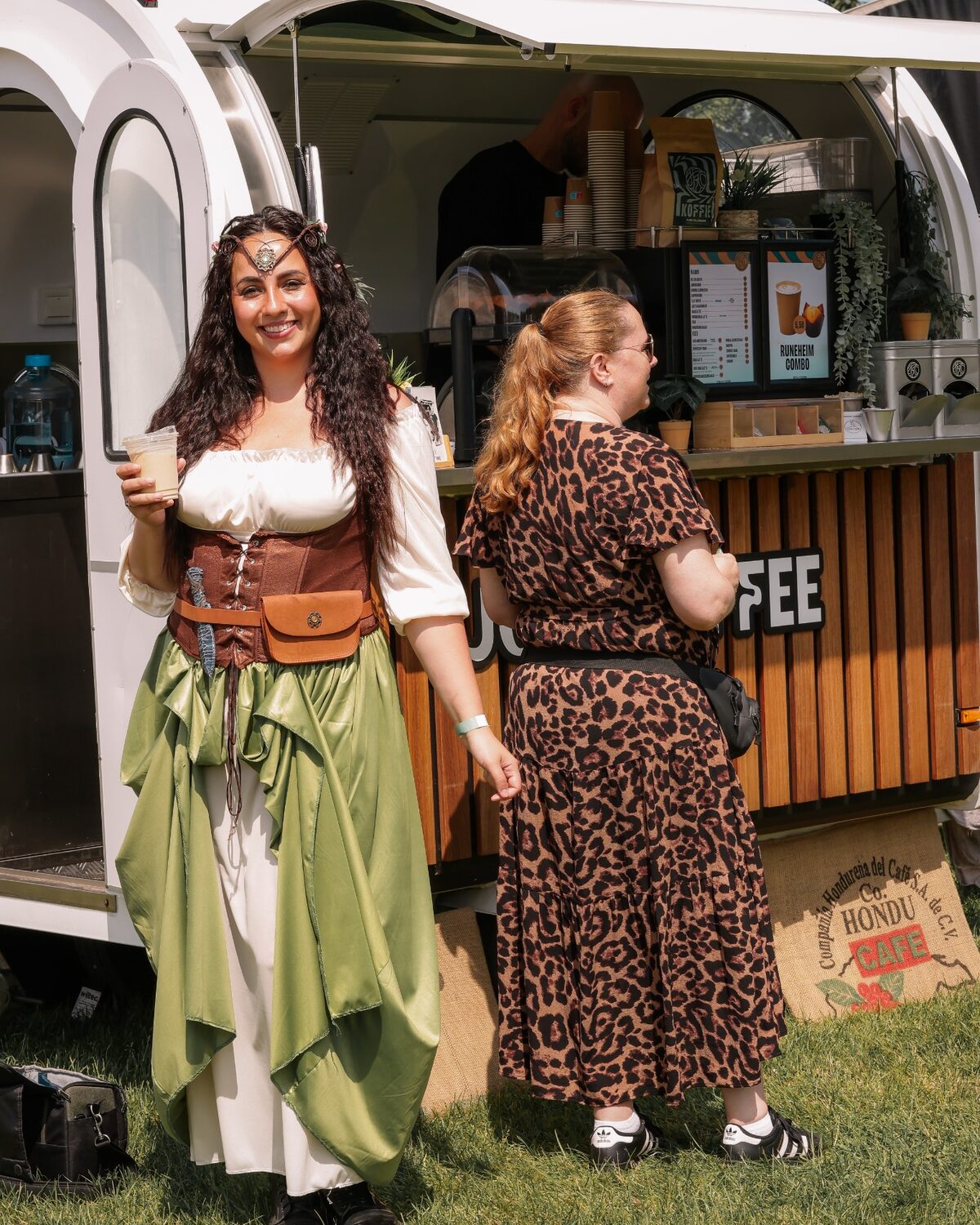 Festivalbezoeker met koffie voor de koffietrailer van Joy of Coffee
