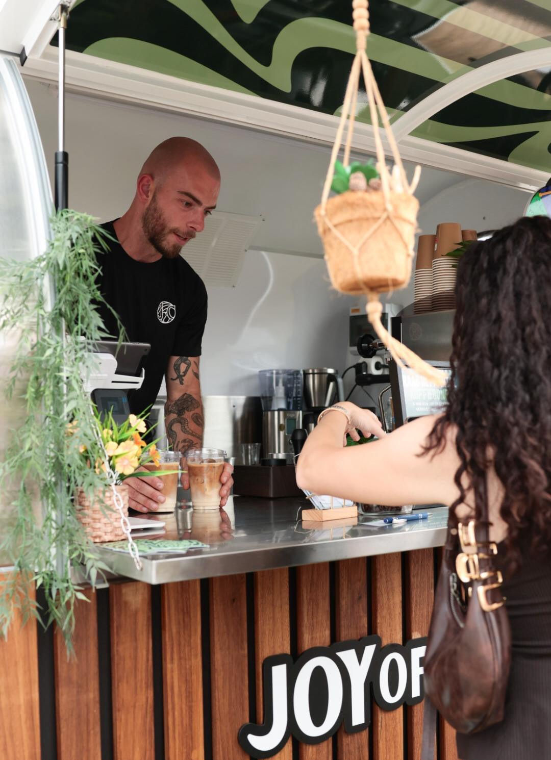 Mobiele koffietrailer van Joy of Coffee op een festival met barista en klanten
