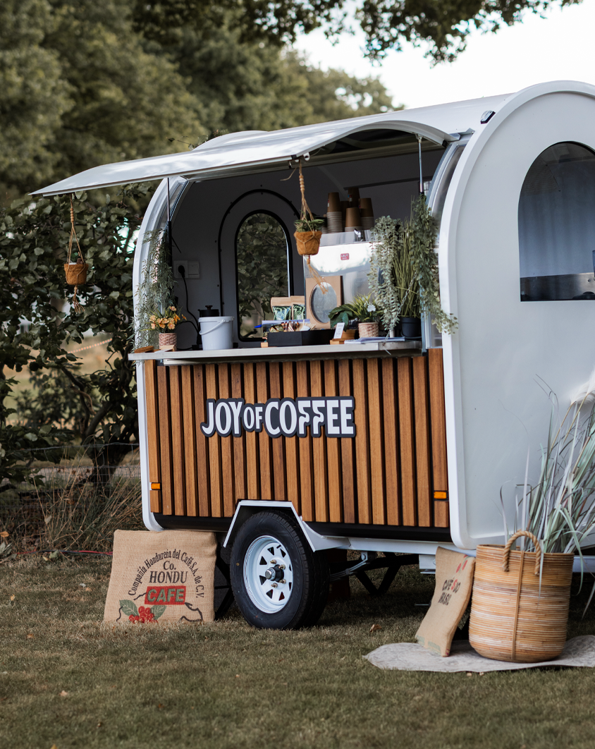 Stijlvolle Joy of Coffee mobiele koffietrailer op een buitenlocatie klaar om koffie te serveren op evenementen